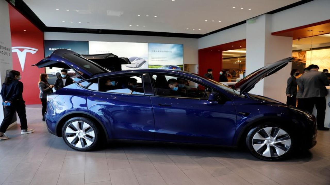 Foto Dokumen: Pengunjung yang mengenakan masker wajah memeriksa kendaraan sport utility vehicle (SUV) Tesla Model Y buatan China di ruang pamer pembuat kendaraan listrik di Beijing, China 5 Januari 2021. ANTARA/REUTERS/Tingshu Wang