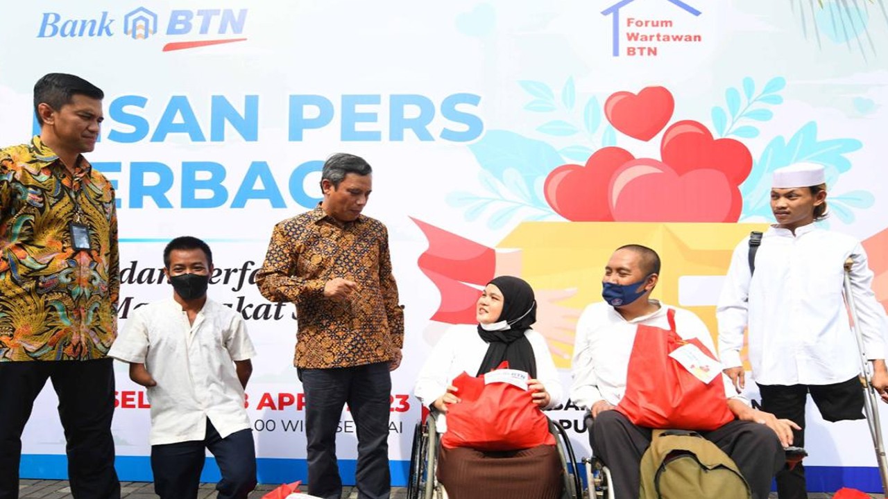 Direktur Utama Bank BTN Nixon LP Napitupulu berbincang dengan salah seorang penerima bantuan  dalam acara BTN dan Insan Pers Berbagi Paket Sembako, Selasa (18/4/2023).