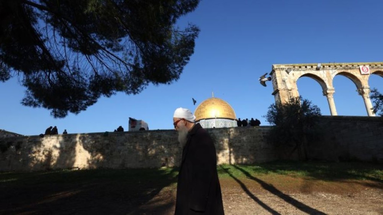 Seorang pria Palestina berfoto pada salat Jumat terakhir bulan suci Ramadhan di luar Masjid Al-Aqsa di Kota Tua Yerusalem, 14 April 2023. (EPA)