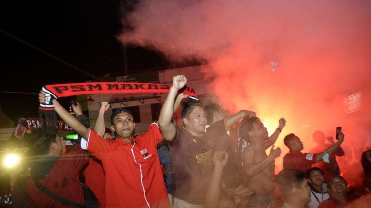 Suporter PSM Makassar menyalakan flare usai nonton bareng pertandingan BRI Liga 1 antara PSM Makassar melawan Madura United di Makassar, Sulawesi Selatan, Jumat (31/3/2023). PSM Makassar mengalahkan tuan rumah Madura United dengan skor 3-1 dan memastikan meraih gelar juara BRI Liga 1 2022/2023. ANTARA FOTO/Abriawan Abhe/tom.