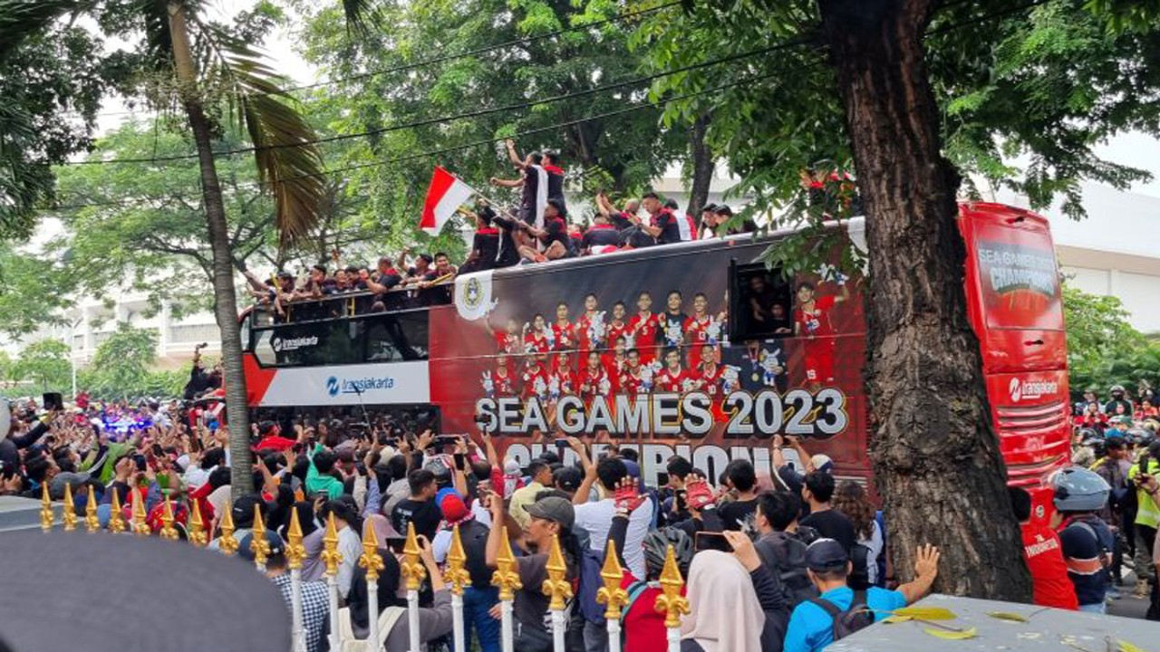 Sejumlah pemain Timnas U-22 Indonesia menaiki atap bus saat arak-arakan peraih 87 emas SEA Games 2023 di halaman Kemenpora Jakarta, Jumat (19/5/2023). (Foto: Antara)