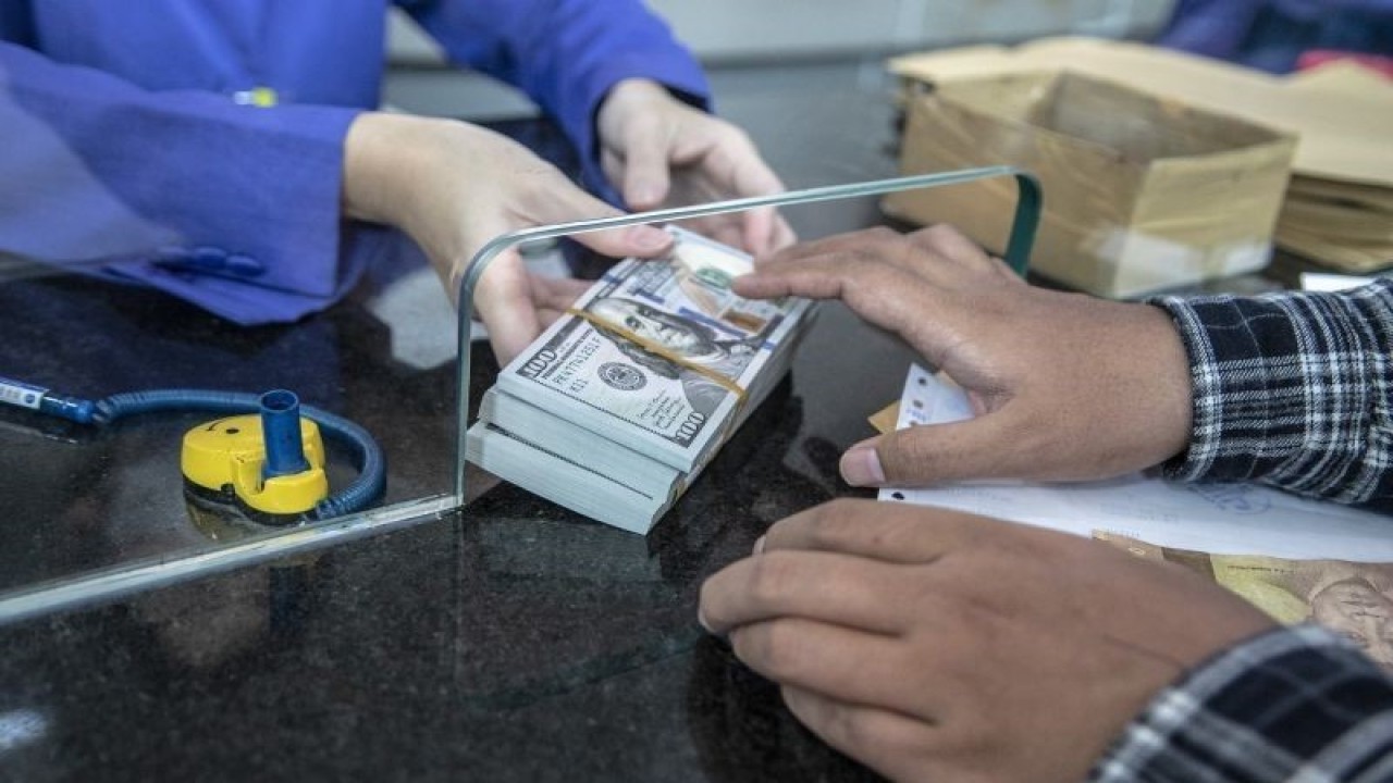 Petugas memberikan uang pecahan dolar AS kepada pembeli di gerai penukaran mata uang asing VIP (Valuta Inti Prima) Money Changer, Jakarta, Selasa (4/10/2022). (ANTARA FOTO/Muhammad Adimaja/aww.)