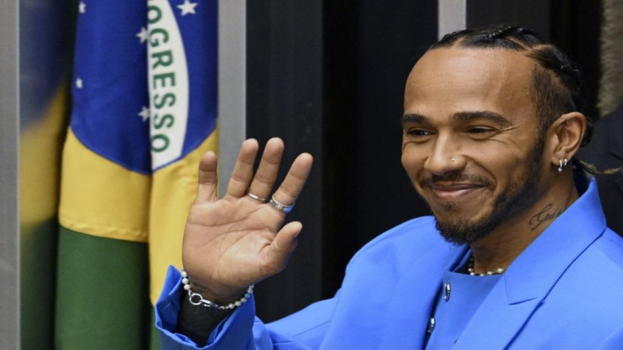 Foto arsip - Pebalap Formula 1 Lewis Hamilton melambaikan tangan saat menerima gelar warga negara kehormatan Brasil pada upacara di Kongres Nasional Brasil, di Brasilia. (7/11/2022). ANTARA/AFP/EVARISTO SA.
