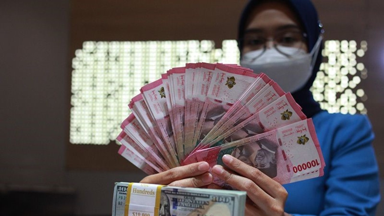 Petugas perbankan menunjukkan uang dolar AS dan uang rupiah, Jakarta, Selasa (31/1/2023). ANTARA FOTO/Reno Esnir/tom/aa. (ANTARA FOTO/RENO ESNIR)