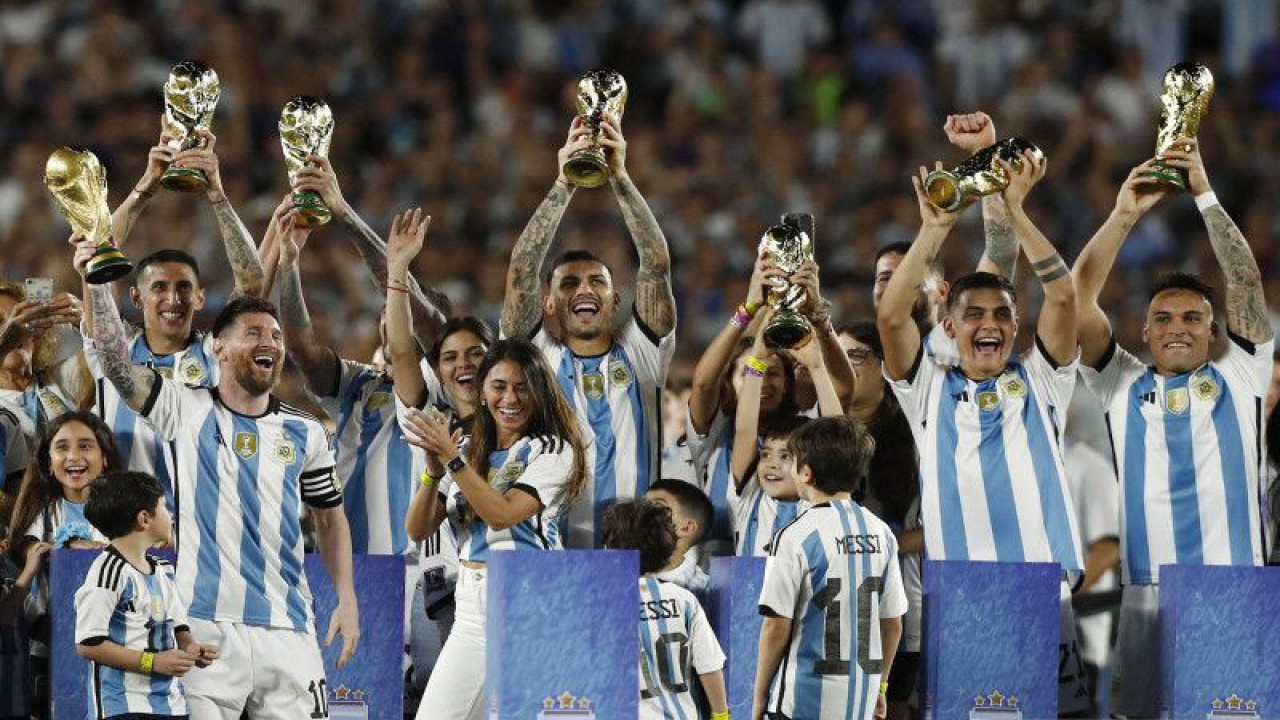 Pemain timnas Argentina berfoto dengan trofi Piala Dunia yang asli beserta sejumlah replikanya usai laga persahabatan melawan Panama di Estadio Monumental, Buenos Aires, Argentina, Kamis (23/3/2023). Argentina menang dengan skor 2-0. ANTARA FOTO/REUTERS/Agustin Marcarian/foc.