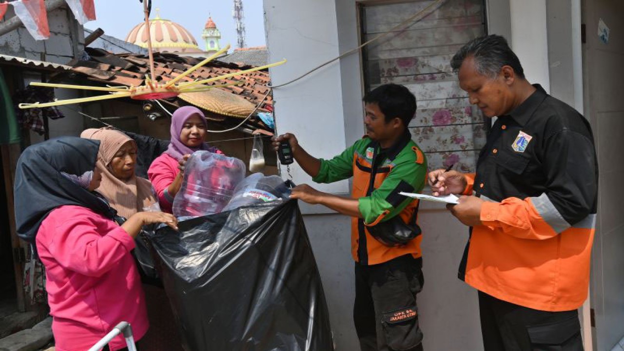 Petugas Bank Sampah Menimbang Limbah Plastik Dari Warga Di RW 01 ...