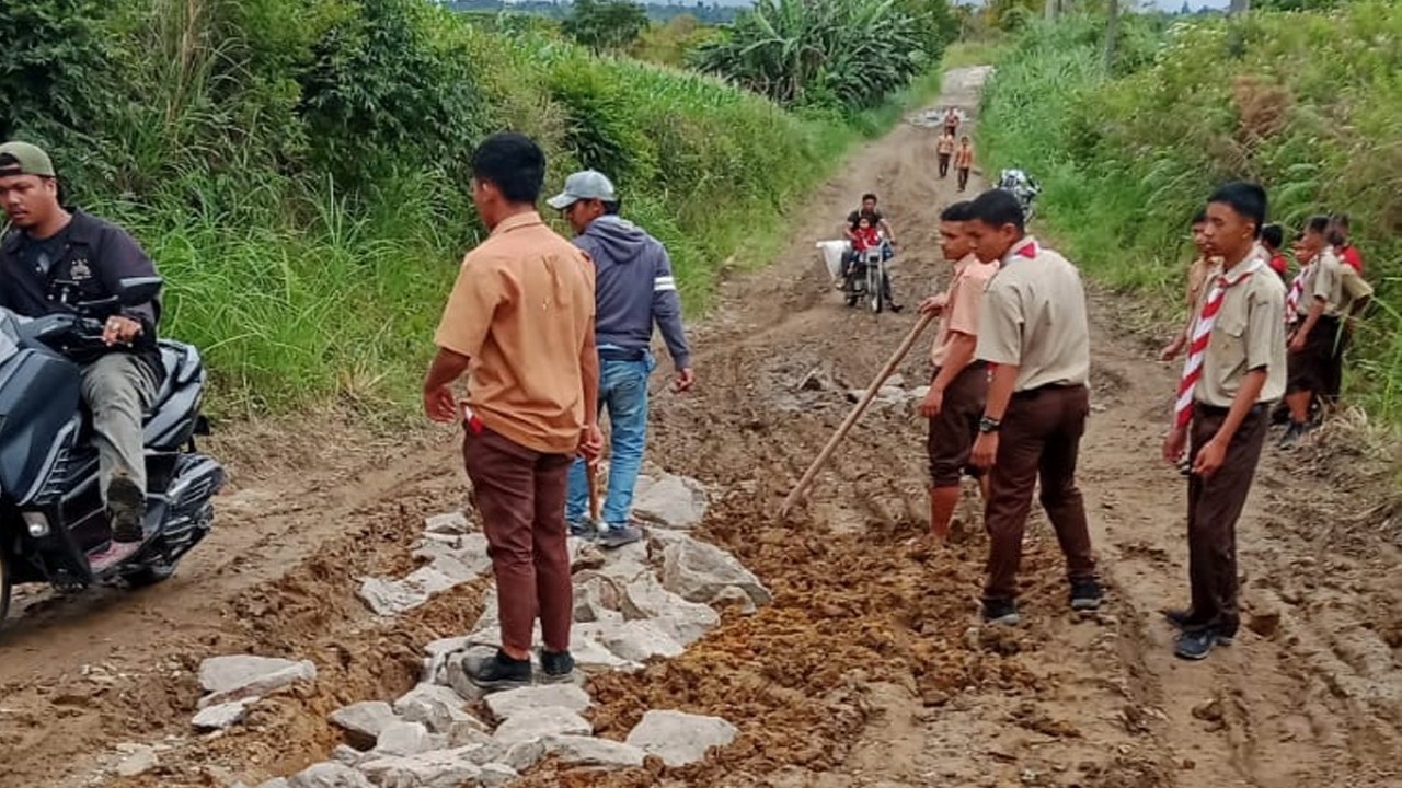 Warga dan para siswa bergotong-royong menimbun dengan batu jalan Provinsi di kampung mereka yang rusak para agar bisa dilalui kendaraan/ist  