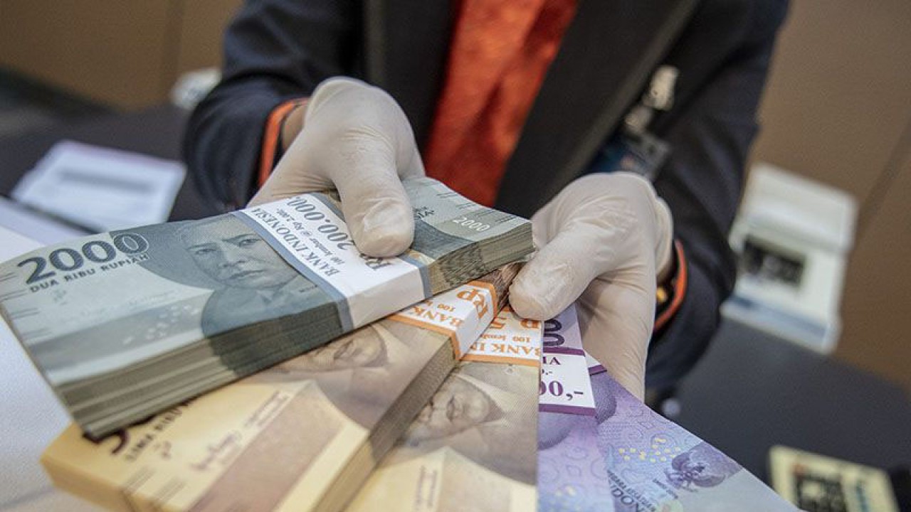 Petugas bank menunjukkan uang pecahan rupiah di BNI KC Mega Kuningan, Jakarta, Selasa (22/11/2022). ANTARA FOTO/Muhammad Adimaja/aww/pri.