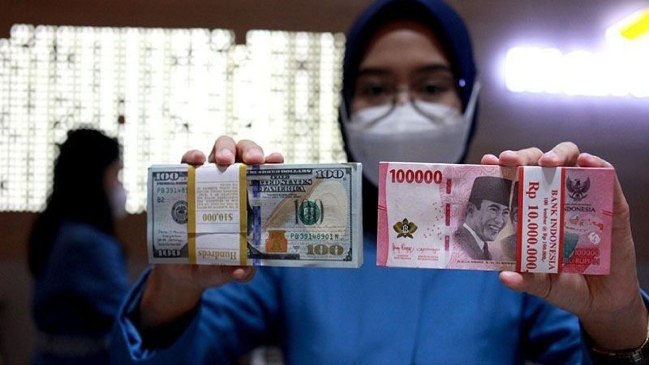 Ilustrasi - Petugas menunjukkan uang dolar AS dan uang rupiah di salah satu kantor cabang PT Bank Mandiri Persero Tbk, Jakarta, Selasa (31/1/2023). (ANTARA FOTO/Reno Esnir/tom/pri.)