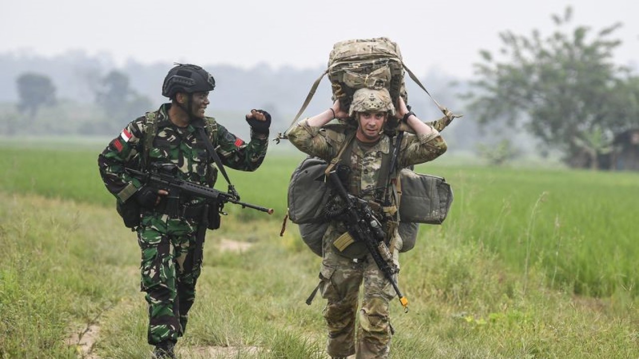 Seorang prajurit TNI AD (kiri) berjalan bersama dengan seorang prajurit Angkatan Darat Amerika Serikat atau US Army usai melakukan penerjunan saat Latihan Bersama Super Garuda Shield (SGS) Tahun 2022 di Pusat Latihan Tempur (Puslatpur) di Baturaja, Ogan Komering Ulu, Sumatera Selatan, Rabu (3/8/2022). Latihan Bersama Super Garuda Shield 2022 yang diikuti 13 negara peserta yakni Indonesia, Amerika Serikat, Australia, Jepang, Malaysia, Singapura, Papua Nugini, Korea Selatan, India, Timor Leste, Kanada, Prancis dan Inggris dilaksanakan di Puslatpur Baturaja, Puslatpur Marinir di Dabo Singkep dan Puslatpur Amborawang tersebut berlangsung hingga 14 Agustus mendatang. ANTARA FOTO/M Risyal Hidayat/rwa.