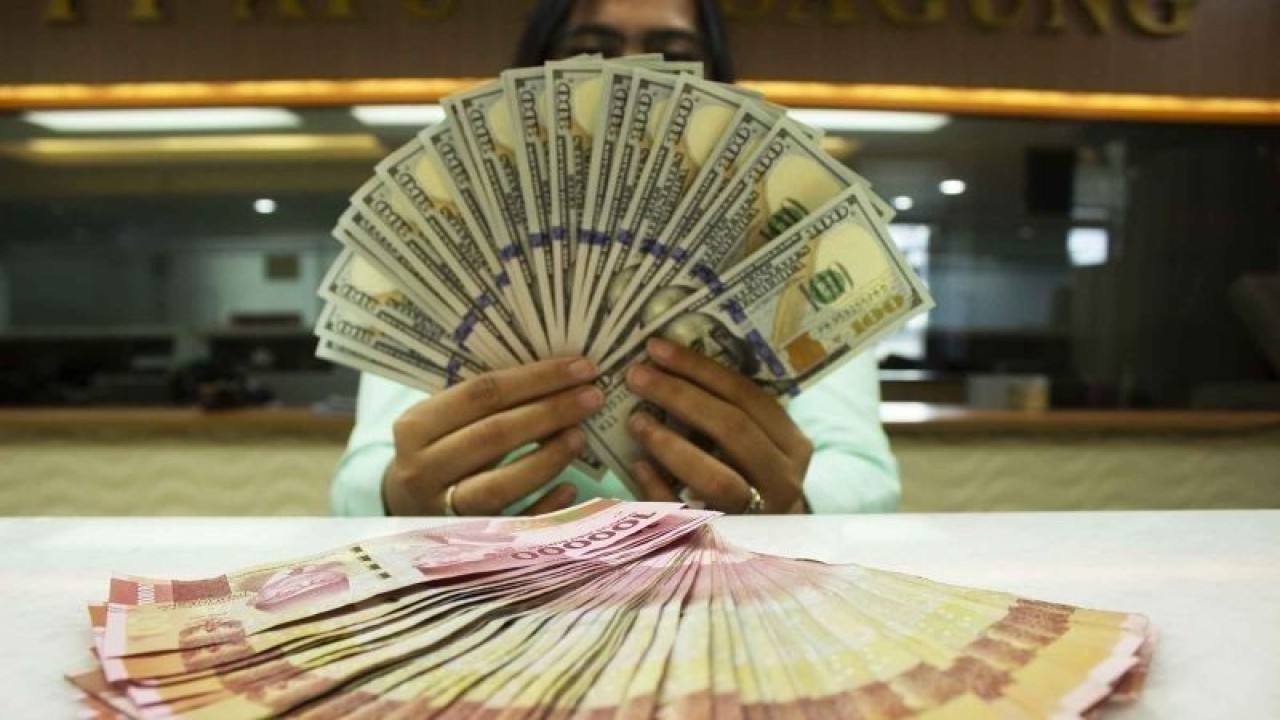 Teller memegang mata uang dolar AS dan rupiah di sebuah tempat penukaran uang di Jakarta, Rabu (6/7/2022). ANTARA FOTO/Subur Atmamihardja/wsj/foc.