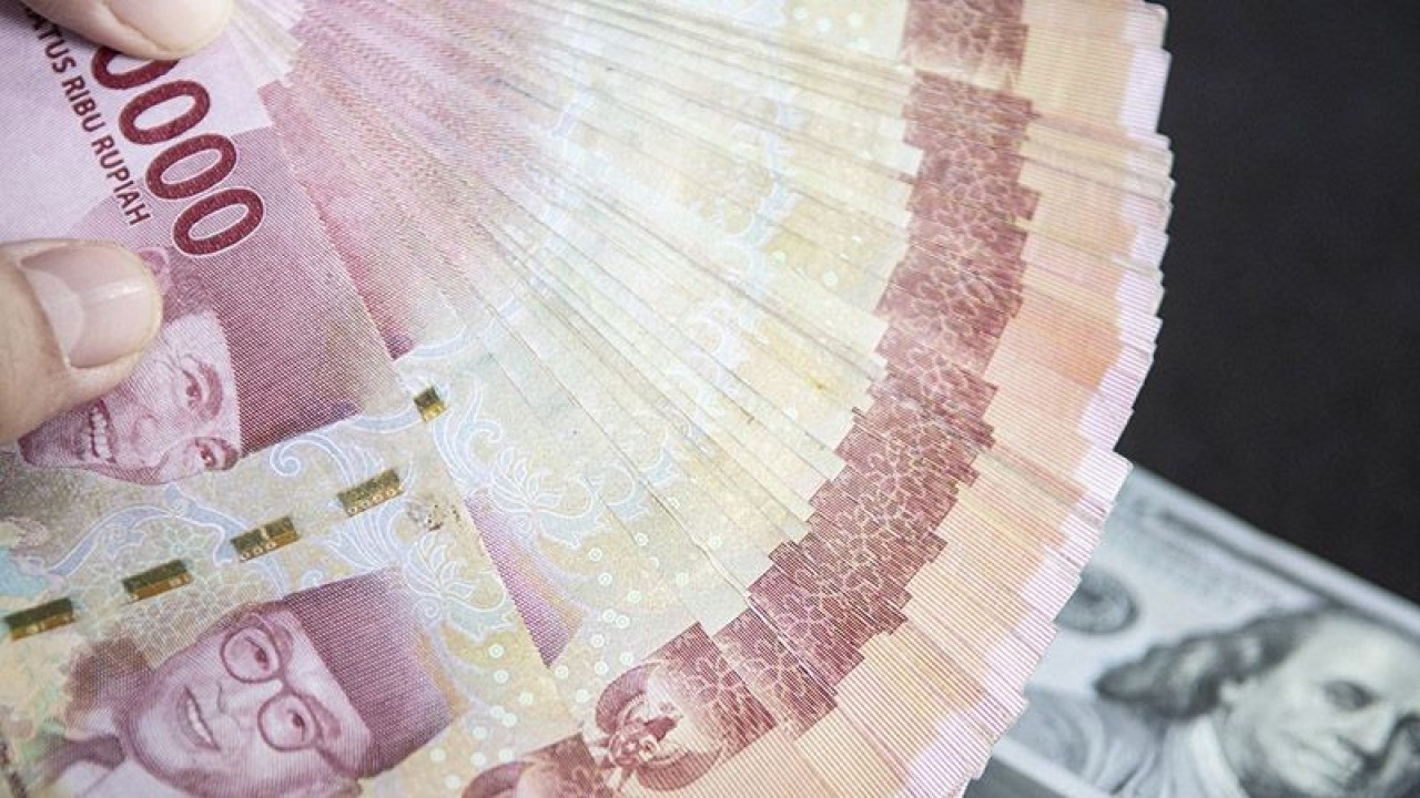 Ilustrasi - Petugas menunjukan uang pecahan rupiah dan dolar AS di gerai penukaran mata uang asing VIP (Valuta Inti Prima) Money Changer, Jakarta, Selasa (3/1/2023). ANTARA FOTO/Muhammad Adimaja/foc/pri.