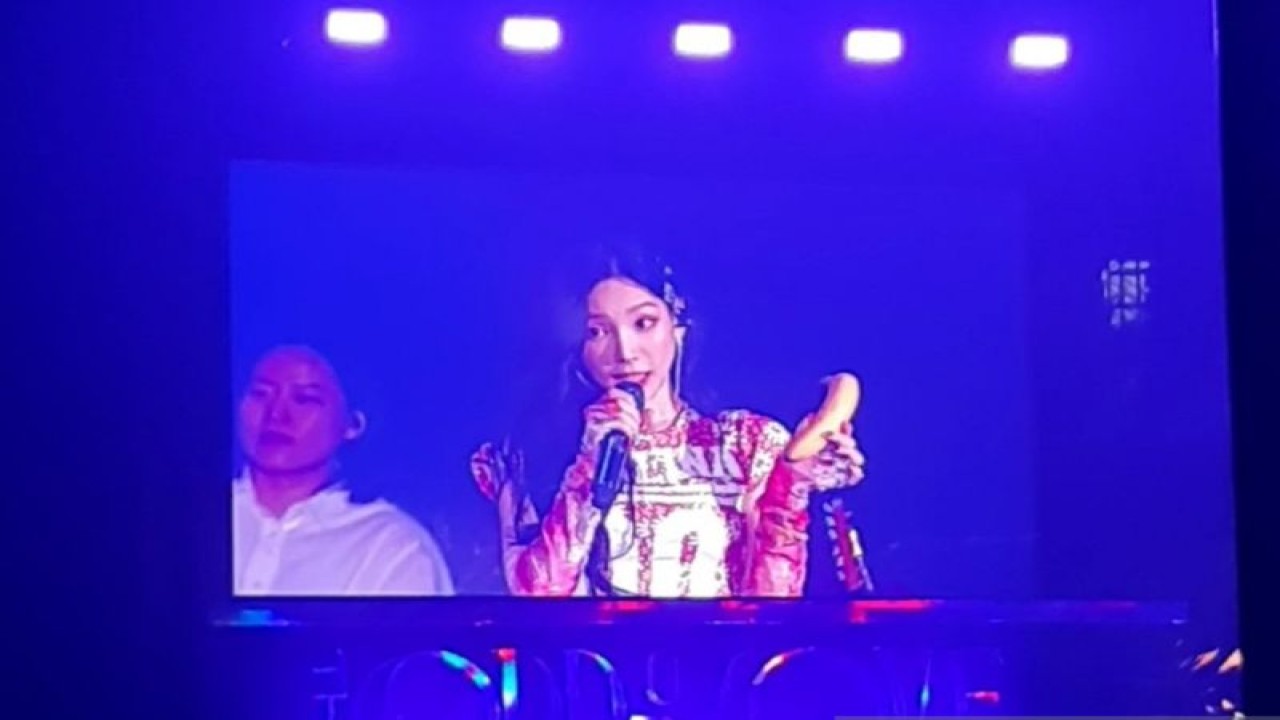 Penyanyi Kim Tae-yeon atau dikenal dengan Taeyeon yang juga pemimpin grup idola K-pop SNSD atau Girls' Generation mengangkat pisang yang tersaji di atas panggung konser "The ODD of LOVE in JAKARTA" di ICE BSD City pada Sabtu (22/7/2023). (ANTARA/Lia Wanadriani Santosa)