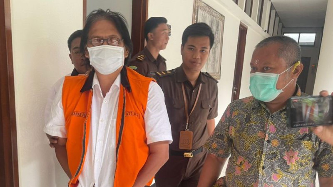 Penyidik membawa tersangka dugaan tindak pidana korupsi mantan Kepala UPTD PAM Dinas Pekerjaan Umum dan Penataan Ruang Perumahan dan Kawasan Pemukiman RAS menuju mobil tahanan di Kejaksaan Tinggi Bali. ANTARA/Rolandus Nampu.