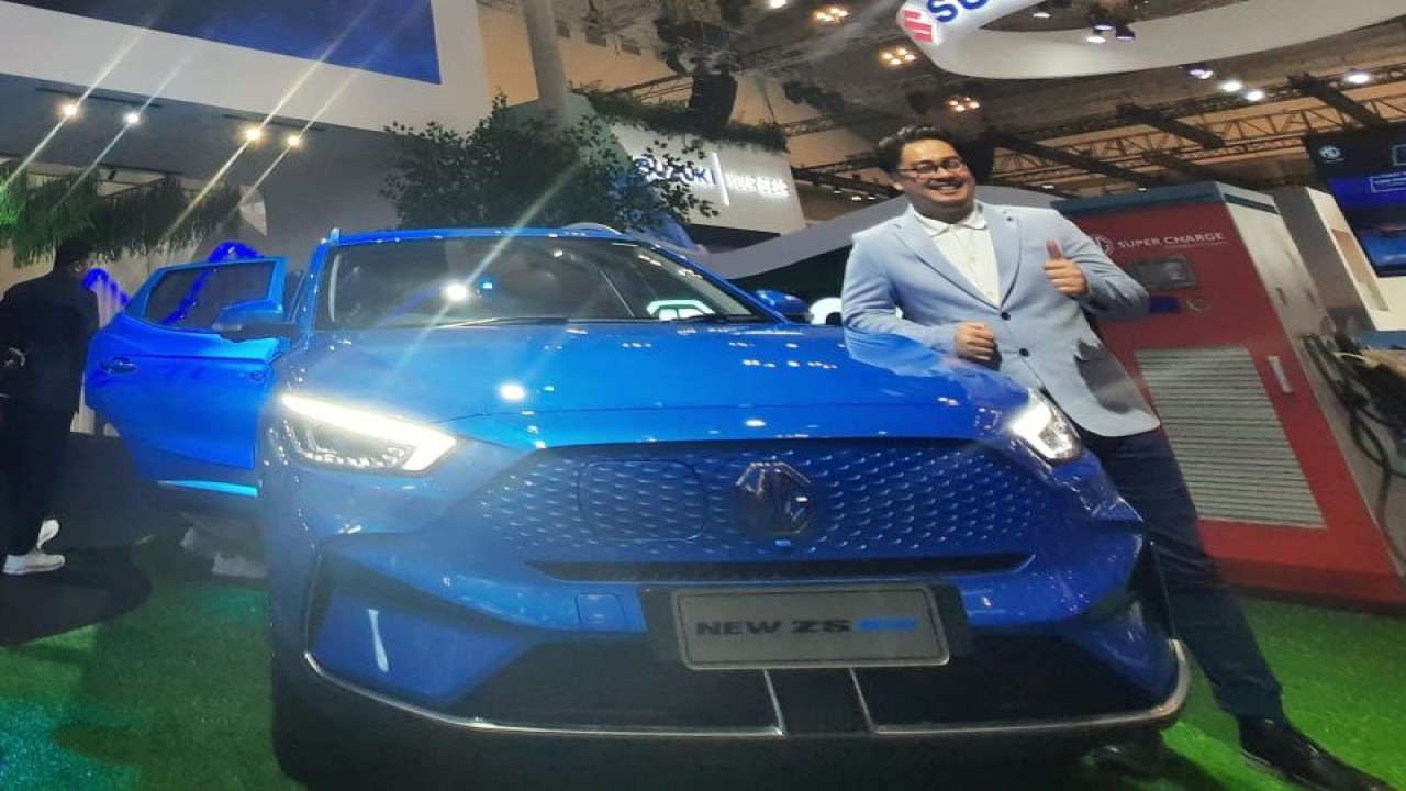 Marketing and PR Director MG Motor Indonesia, Arief Syarifudin berfoto bersama dengan MG New ZS EV di GIIAS 2023. (ANTARA/Chairul Rohman)