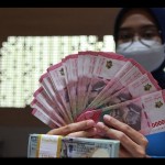 Petugas perbankan menunjukkan uang dolar AS dan uang rupiah, Jakarta, Selasa (31/1/2023). (ANTARA FOTO/Reno Esnir/tom/aa)-1692770704