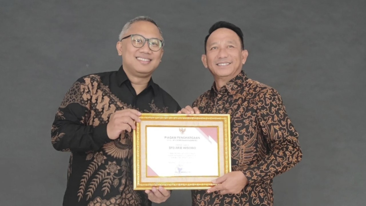 Bupati Belitung Timur, Drs Burhanudin (kiri) memberikan penghargaan kepada pegiat pendidikan SFD Arie Wibowo