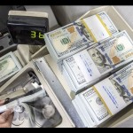 Ilustrasi - Petugas bank menghitung uang dolar AS. ANTARA FOTO/Muhammad Adimaja/YU/aa.-1694068786