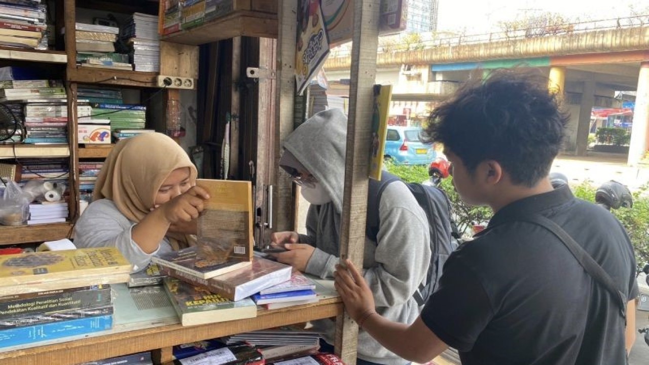 Penjual di Pasar Kwitang, Jakarta Selatan melayani anak-anak muda membeli buku bekas. (ANTARA/Hreeloita Dharma Shanti)
