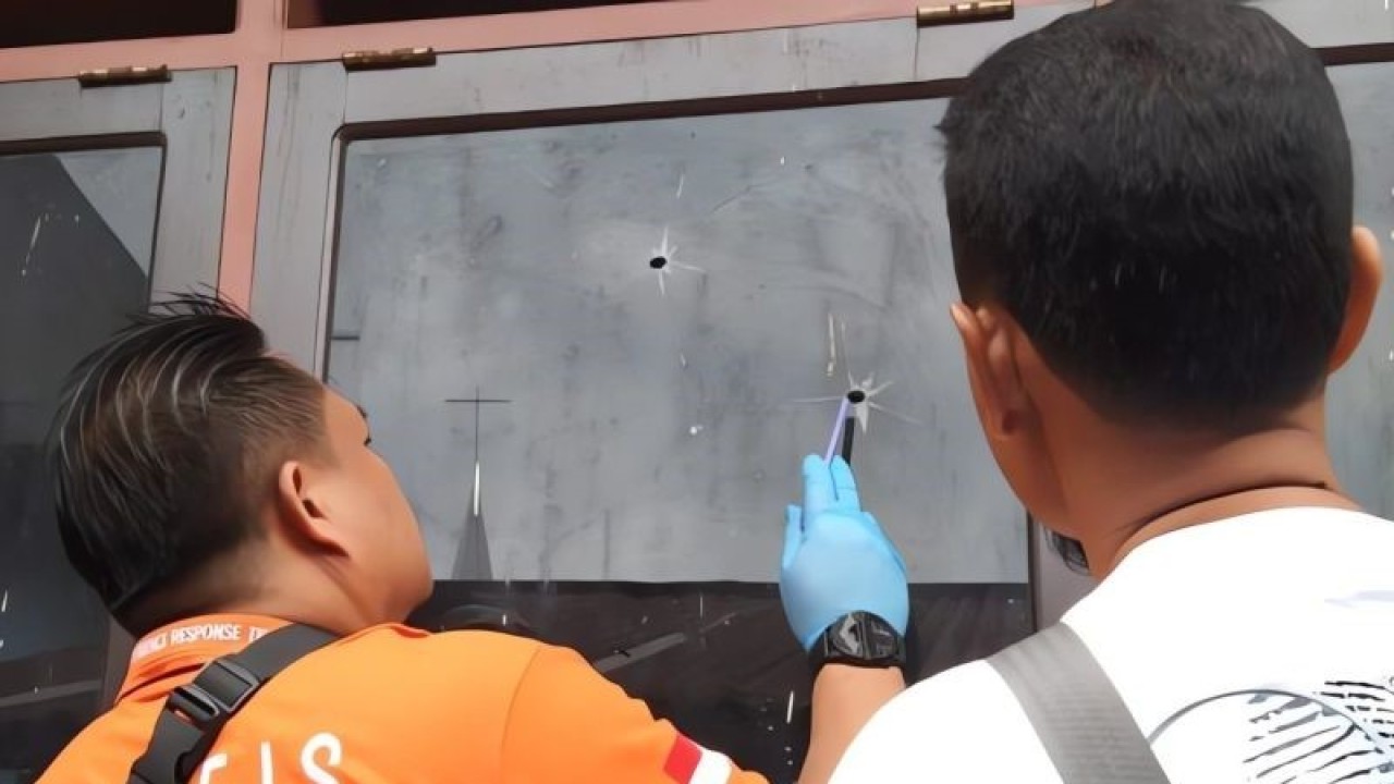 Tampak tim inafis sedang menyelidiki dua lubang dikaca jendela SDN 38 Kota Sorong yang diduga ditembak oknum tak dikenal, Selasa (19/9) (ANTARA/Yuvensius Lasa Banafanu)