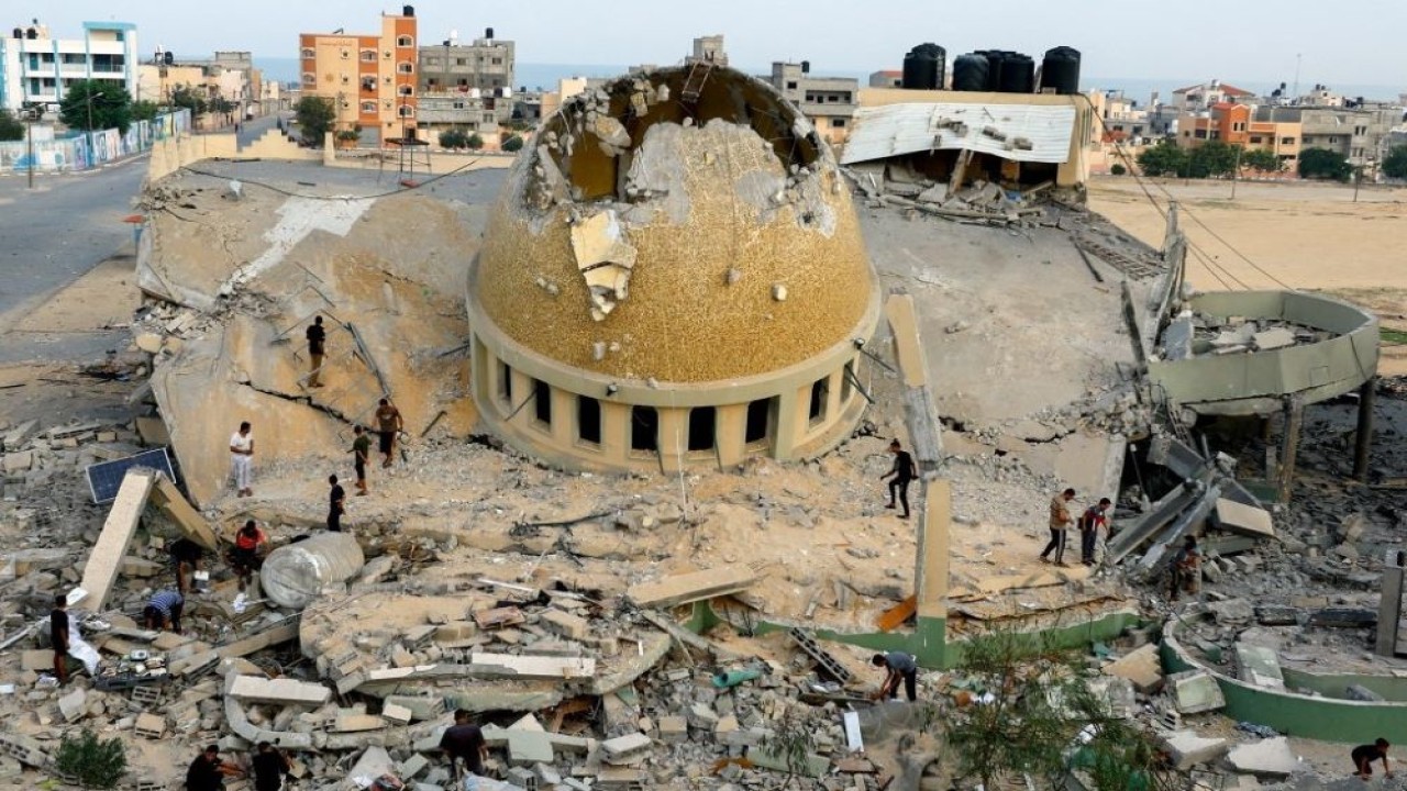 Warga Palestina memeriksa sebuah Masjid yang hancur akibat serangan Israel di Khan Younis, di selatan Jalur Gaza, 8 Oktober 2023. (Reuters)