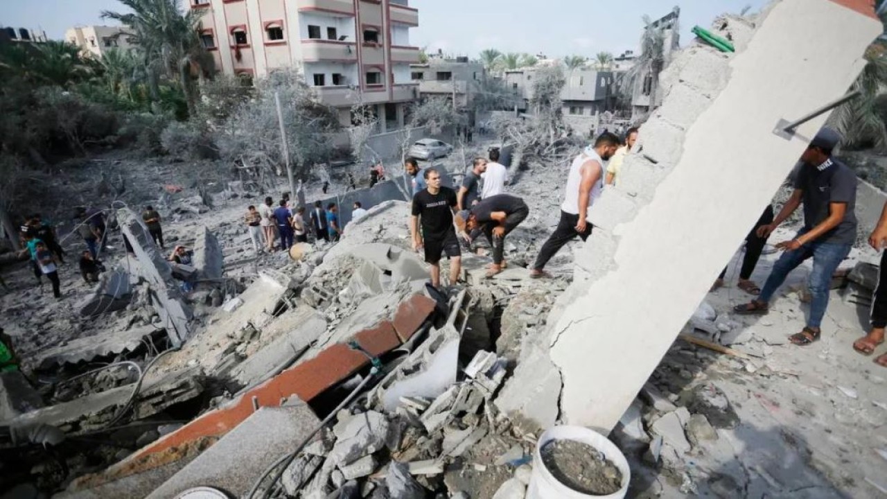 Warga Palestina melakukan operasi pencarian dan penyelamatan di bawah puing-puing bangunan yang hancur pasca serangan udara Israel di Deir al-Balah, Gaza, pada 22 Oktober 2023. (Ashraf Amra/Anadolu Agency)