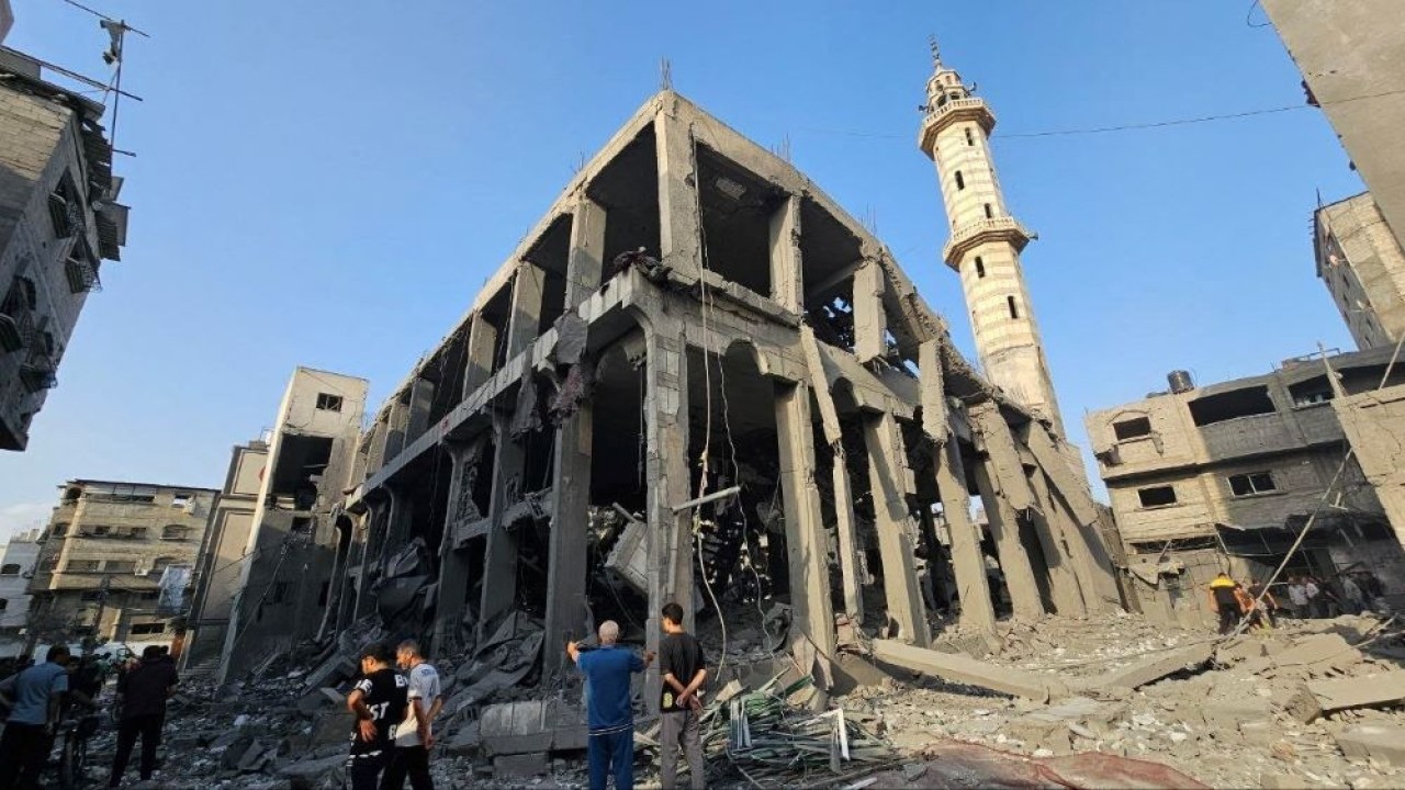 Warga Palestina berkumpul di sekitar sissa-sisa masjid yang hancur akibat serangan Israel di jalur Gaza utara, Palestina, 22 Oktober 2023. (Reuters)