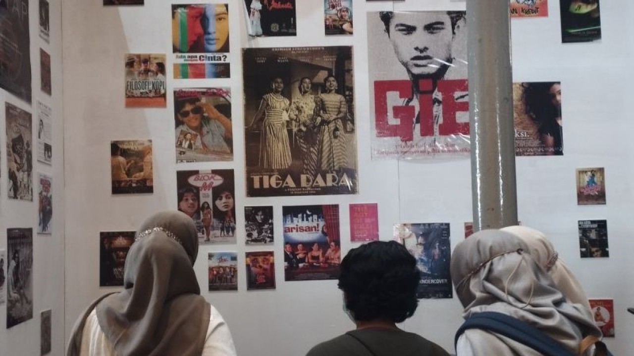 Pengunjung mengamati poster-poster film nasional yang dipamerkan dalam pameran temporer Jejak Memori Gempita Layar Perak Jakarta di Museum Sejarah Jakarta, Senin (9/10/2023). ANTARA/Nabil Ihsan.