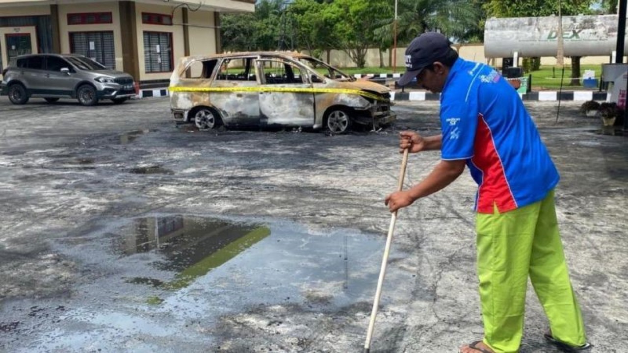 Pekerja membersihkan material kebakaran paska terjadinya musibah kebakaran terhadap sebuah minibus Toyota Innova, BL 1843 JW di Stasiun Pengisian Bahan Bakar Umum (SPBU) Suak Puntong, Kecamatan Kuala Pesisir, Kabupaten Nagan Raya, Provinsi Aceh, Senin siang (15/10/2023). ANTARA/Teuku D Iskandar