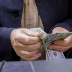 Seorang pria menghitung uang dolar AS di toko penukaran valas, Baghdad, Irak, pada 23 Januari 2023. (ANTARA/REUTERS/Ahmed Saad/as)-1697783352