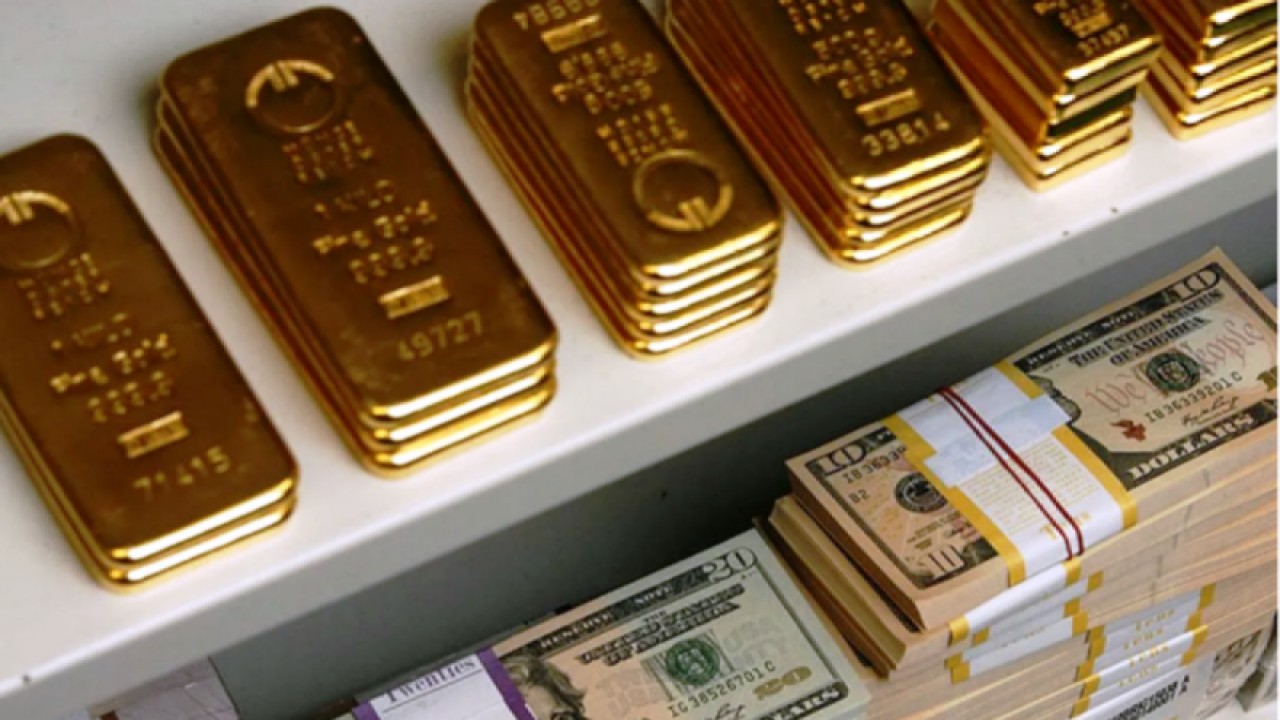 Ilustrasi - Emas batangan dan uang kertas dolar AS dalam brankas. (ANTARA/REUTERS/Heinz-Peter Bader/aa)