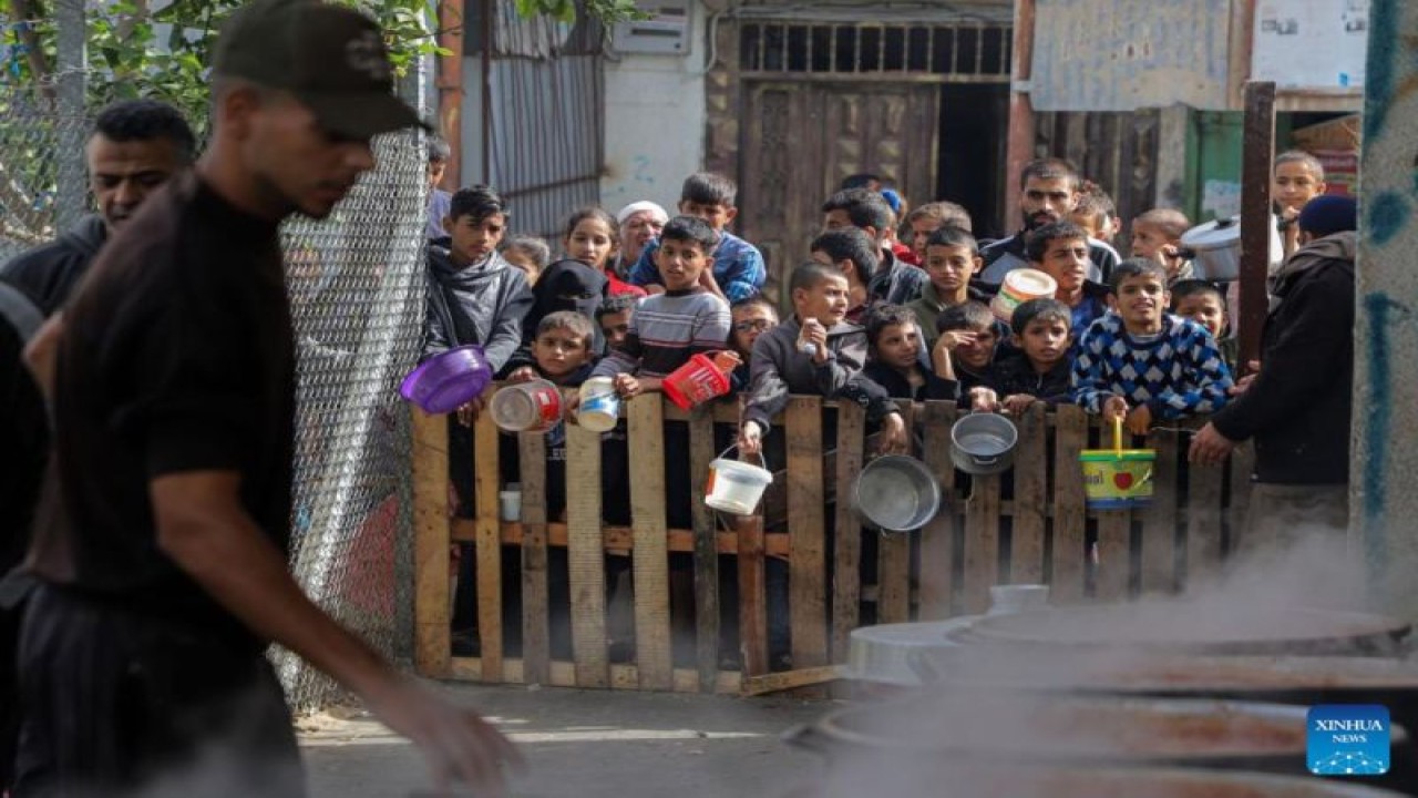 Arsip - Para warga, termasuk anak-anak, menunggu di pagar untuk mendapatkan bantuan makanan di Kota Rafah, Gaza, pada 19 November 2023. ANTARA/Rizek Abdeljawad/Xinhua/tm