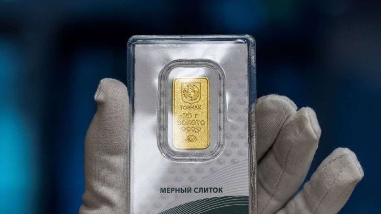 Seorang karyawan menunjukkan batangan emas seberat 20 gram di cabang perusahaan saham gabungan Goznak, Moscow Mint, yang mengumumkan dimulainya penjualan emas batangan kepada individu di Moskow, Rusia, 22 Mei 2023. ANTARA/REUTERS/Maxim Shemetov/pri.