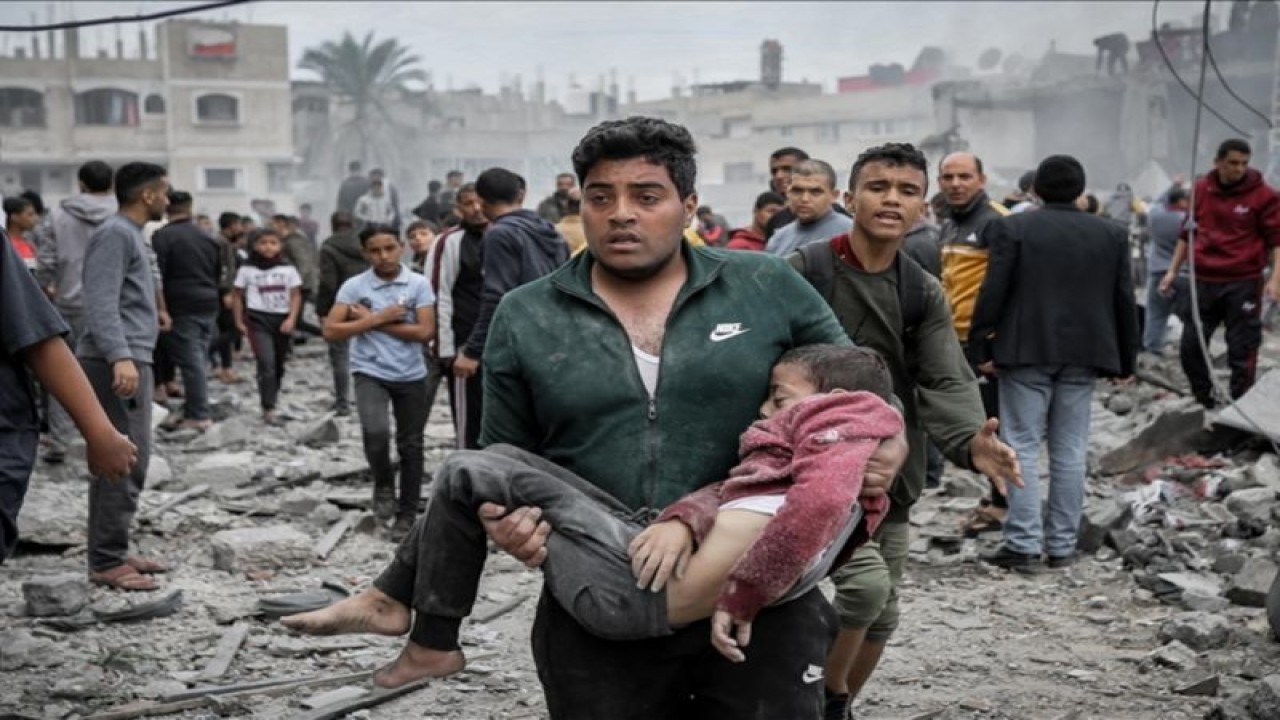 Seorang pria menggendong seorang anak yang tidak sadarkan diri di Gaza. (ANTARA/AA)