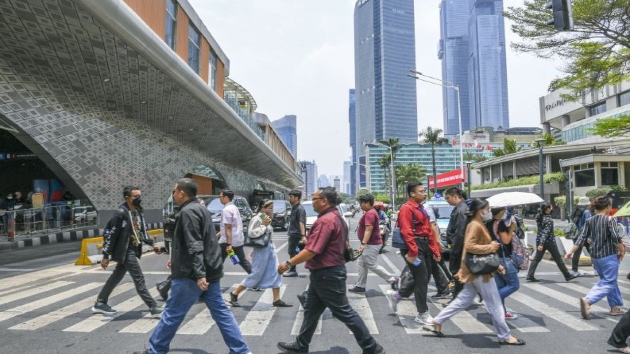 Pekerja melintasi pelican crossing di Jakarta, Senin (9/10/2023). Badan Meteorologi, Klimatologi dan Geofisika (BMKG) mengatakan DKI Jakarta mengalami fenomena Kulminasi Utama atau Hari Tanpa Bayangan, fenomena tersebut adalah ketika matahari tepat berada di posisi paling tinggi di langit. Akibatnya, bayangan akan tegak dan terlihat "menghilang" karena bertumpuk dengan benda itu sendiri. ANTARA FOTO/Galih Pradipta/foc.