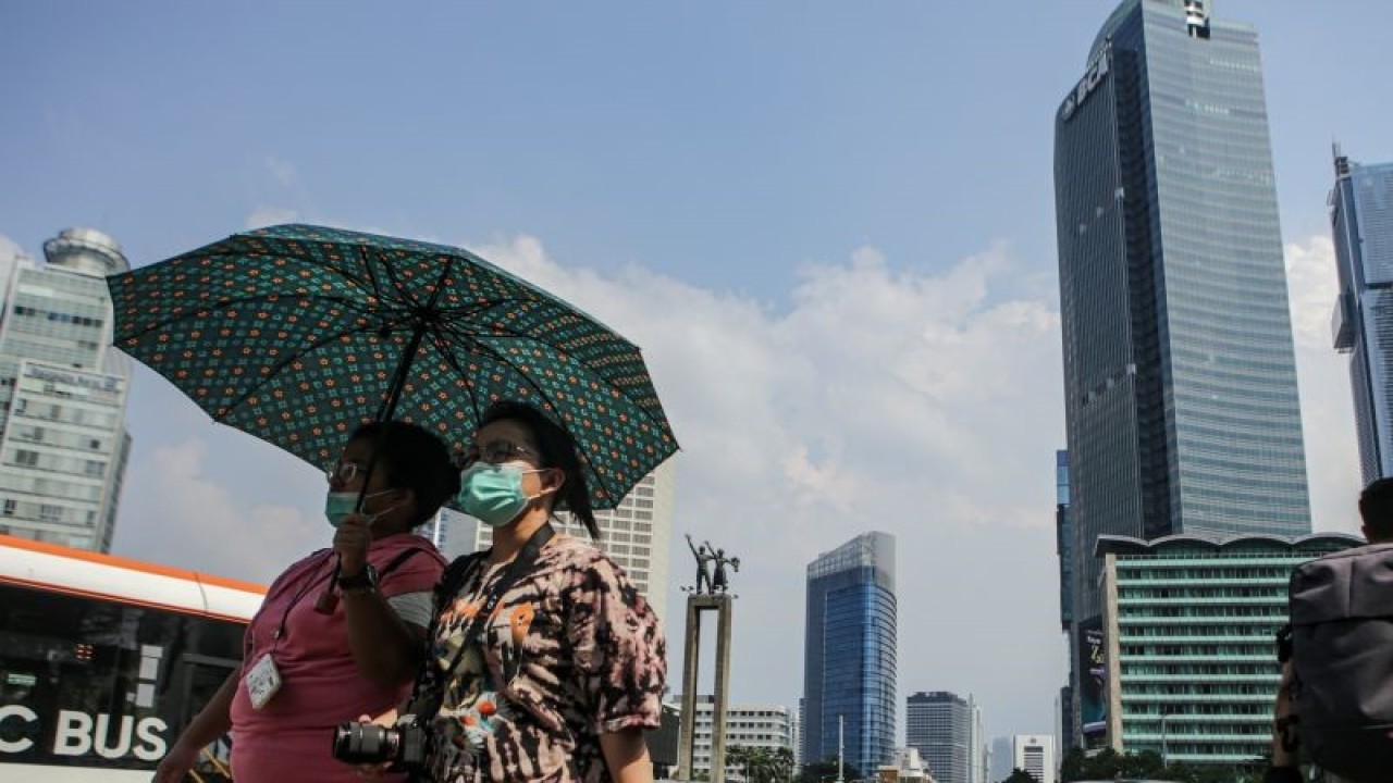 Warga berjalan di tengah cuaca terik di kawasan Bundaran HI, Jakarta, Senin (24/4/2023). Badan Meteorologi Klimatologi dan Geofisika (BMKG) menyampaikan dinamika atmosfer yang tidak biasa menjadi salah satu penyebab Indonesia mengalami suhu panas dalam beberapa hari terakhir. ANTARA FOTO/Fauzan/aww. (ANTARA FOTO/FAUZAN)