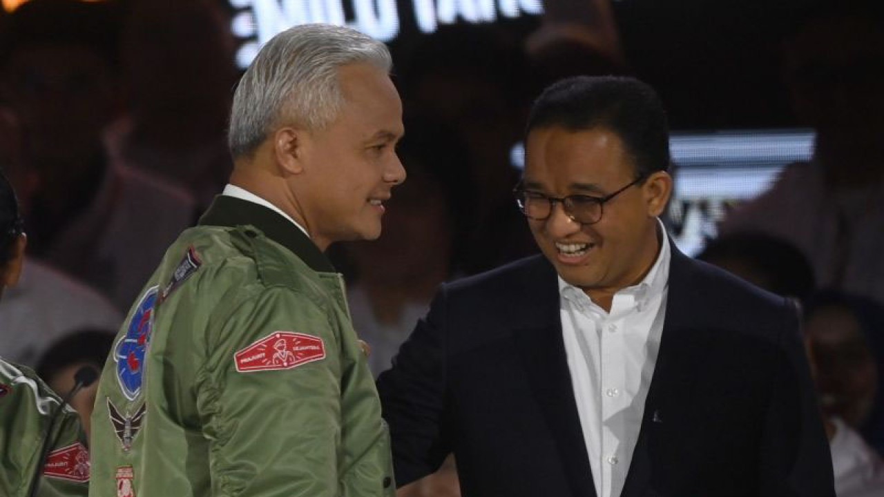 Capres nomor urut tiga Ganjar Pranowo (kiri) berbincang dengan capres nomor urut satu Anies Baswedan usai tiba di lokasi debat ketiga Pilpres 2024 di Istora Senayan, Jakarta, Minggu (7/1/2024) malam. ANTARA FOTO/Aditya Pradana Putra/foc.