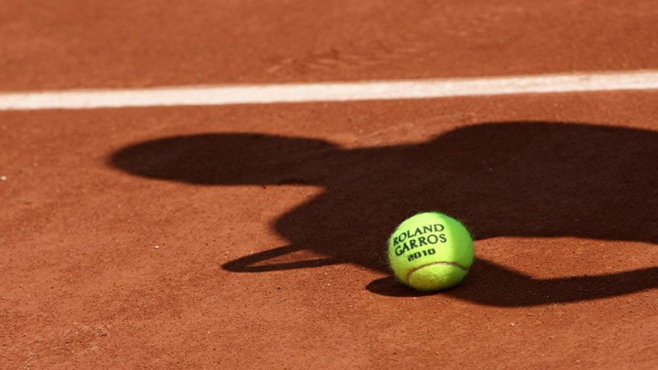 ilustrasi - Bola resmi turnamen tenis dengan bayang-bayang seorang pemain tenis diatas tanah. ANTARA/Shutterstock/pri.