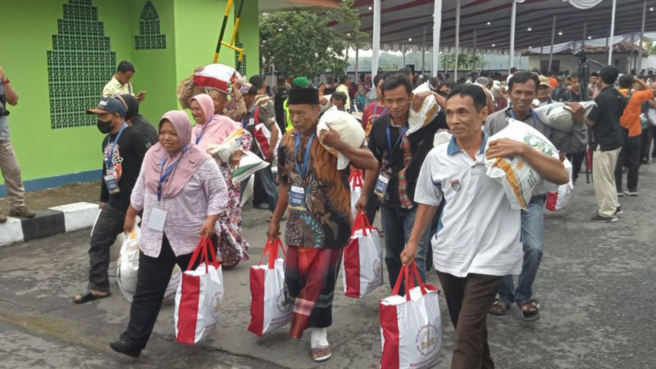 Warga keluar Gudang Bulog Pajangan Bantul usai menerima bantuan pangan beras yang dihadiri Presiden Joko Widodo. Selasa (30/1/2024) (ANTARA/Hery Sidik)