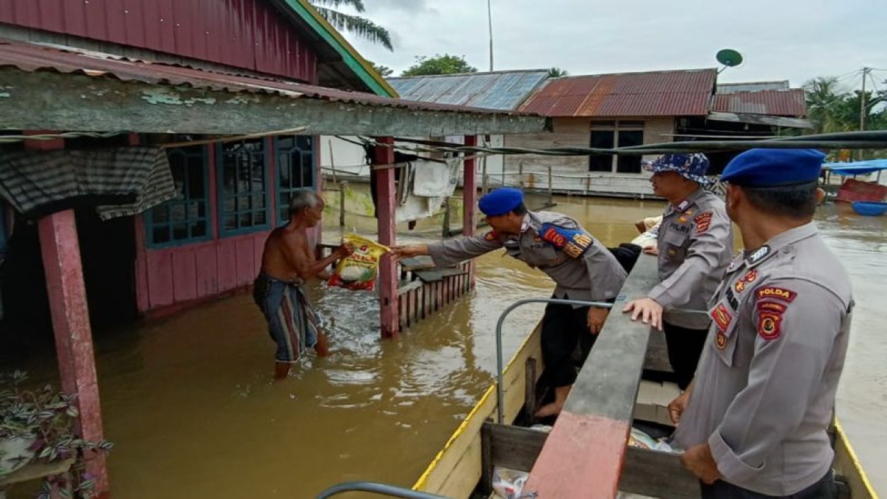 Polisi membagikan bantuan sembako kepada warga korban banjir di Kecamatan Kumpeh, Kabupaten Muaro Jambi, Selasa (16/1/2024). (ANTARA/HO-Polda Jambi)