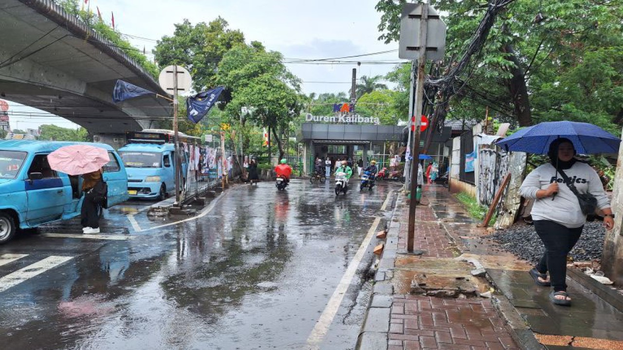 Sejumlah warga mengenakan payung saat cuaca hujan di kawasan sekitar Stasiun Duren Kalibata, Jakarta, Senin (29/1/2024). ANTARA/Luthfia Miranda Putri