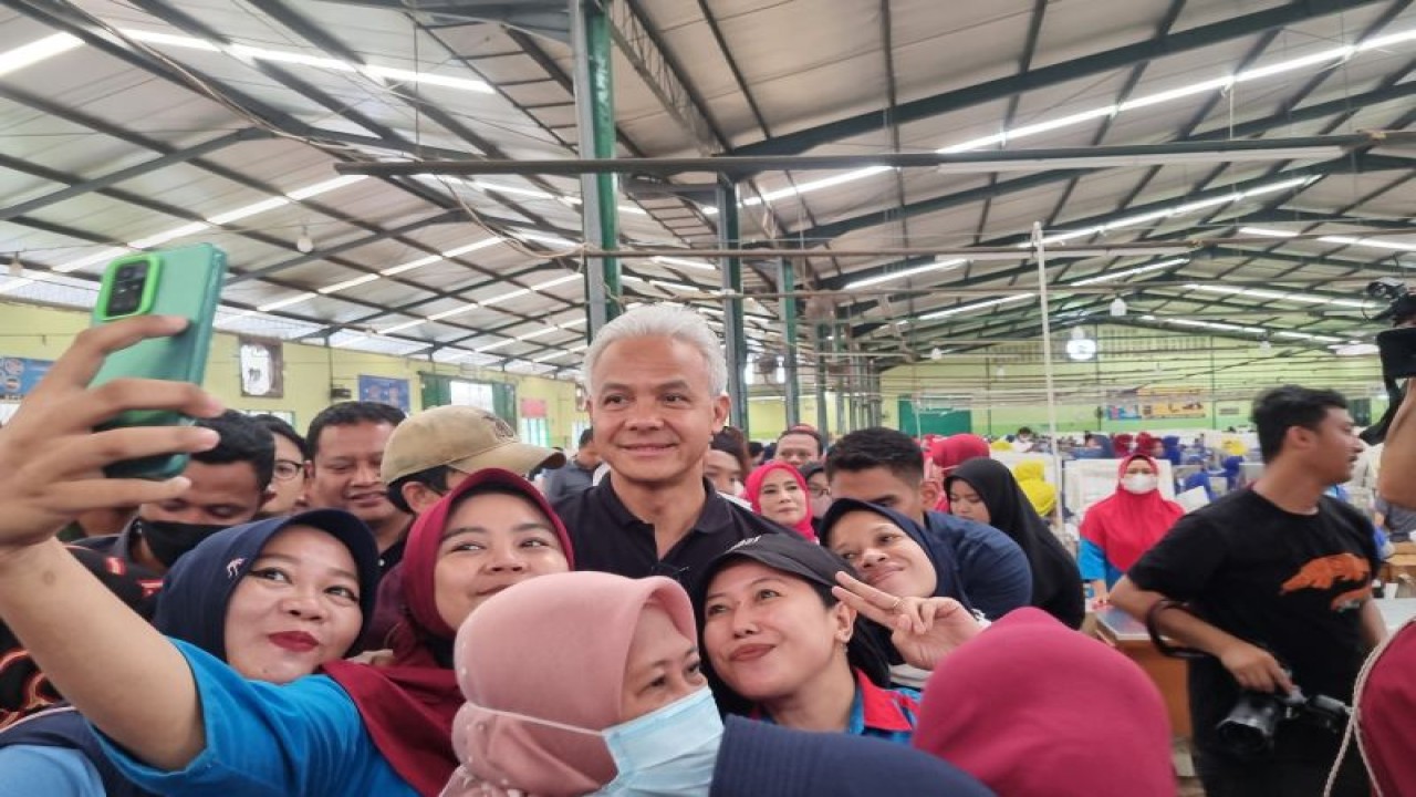 Calon presiden nomor urut 3 Ganjar Pranowo berswafoto dengan para pekerja perempuan saat kunjungan ke PT Sari Tembakau Harum, Kelurahan Cepiring, Kabupaten Kendal, Jawa Tengah, Rabu (17/1/2024). (ANTARA/Anita Permata Dewi)