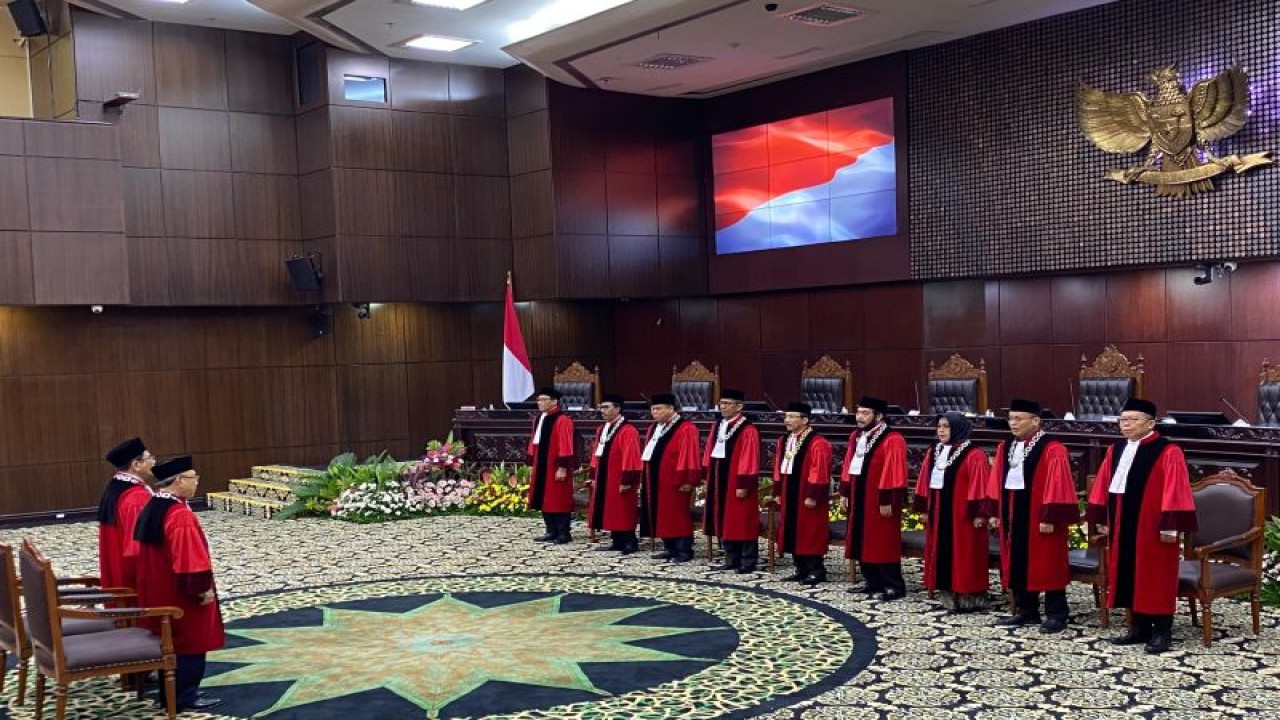 Mantan Hakim Konstitusi Wahiduddin Adams dan Manahan M.P. Sitompul (kiri) berdiri di hadapan sembilan hakim konstitusi saat wisuda purnabakti dan pisah sambut hakim konstitusi di Ruang Sidang Pleno Gedung I MK RI, Jakarta, Kamis (18/1/2024). (ANTARA/Fath Putra Mulya)