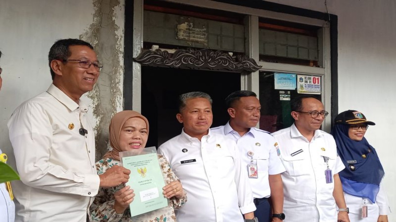 Penjabat (Pj) Gubernur DKI Jakarta Heru Budi Hartono saat menyerahkan sertifikat tanah program Pendaftaran Tanah Sistematis Lengkap (PTSL) kepada warga RT 008 RW 01 Gang Jati, Jalan Kapten Tendean, Mampang Prapatan, Jakarta Selatan, Rabu (24/1/2024). ANTARA/Siti Nurhaliza