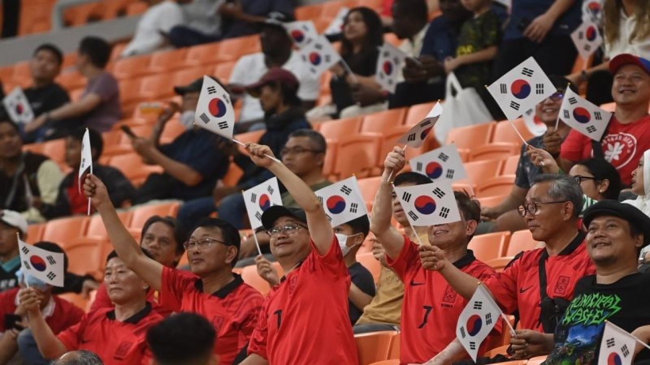 Ilustrasi - Pendukung Timnas Korea Selatan melambaikan bendera saat laga antara Prancis lawan Korea Selatan dalam penyisihan Grup E Piala Dunia U-17 di Jakarta International Stadium, Jakarta, Rabu (15/11/2023). ANTARA FOTO/Akbar Nugroho Gumay/rwa.