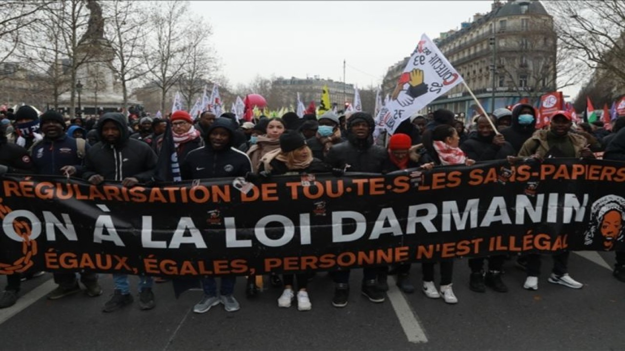 Para pengunjuk rasa berkumpul sambil memegang spanduk dan bendera untuk berdemonstrasi menentang RUU imigrasi Menteri Dalam Negeri Prancis Gerald Darmanin di Paris, Prancis, 14 Januari 2024. ( Mohamad Salaheldin Abdelg Alsayed - Anadolu Agency ) (ANTARA/Anadolu)