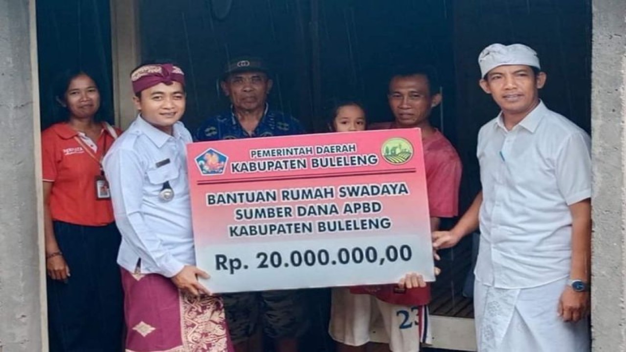 Petugas dari Dinas Perumahan Kawasan Permukiman dan Pertanahan (Perkimta) memberikan bantuan perbaikan rumah secara simbolis di Singaraja, Buleleng, Bali, Selasa (30/1/2024). ANTARA/HO-Diskominfosanti Buleleng