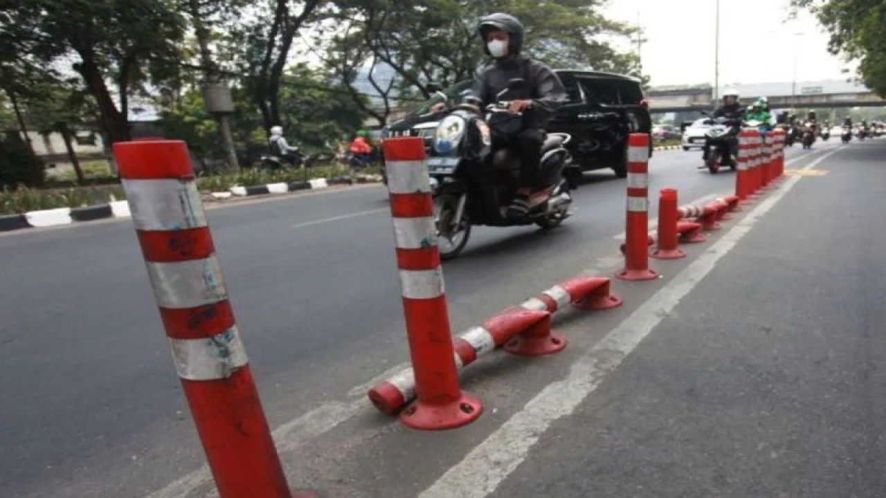 Sejumlah Kendaraan Melintas Disamping Pembatas Jalur Sepeda Stick Cone