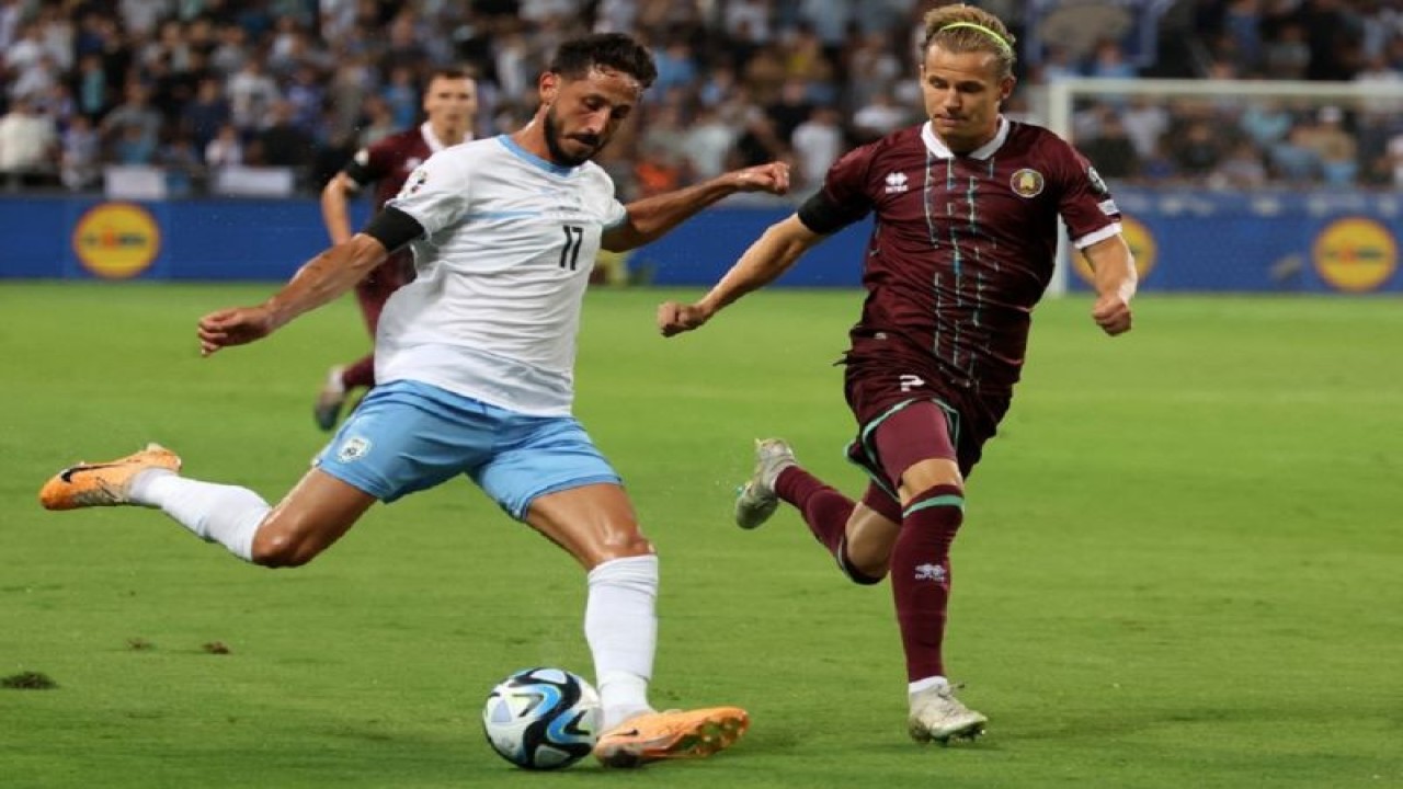 Penyerang Belarus (02) Kiryl Pyachenin berebut bola dengan pemain Israel (17) Sagiv Jehezkel pada lagakualifikasi Grup I Euro 2024 di Bloomfield Stadium, Tel Aviv. (12/9/2023) (AFP/JACK GUEZ)