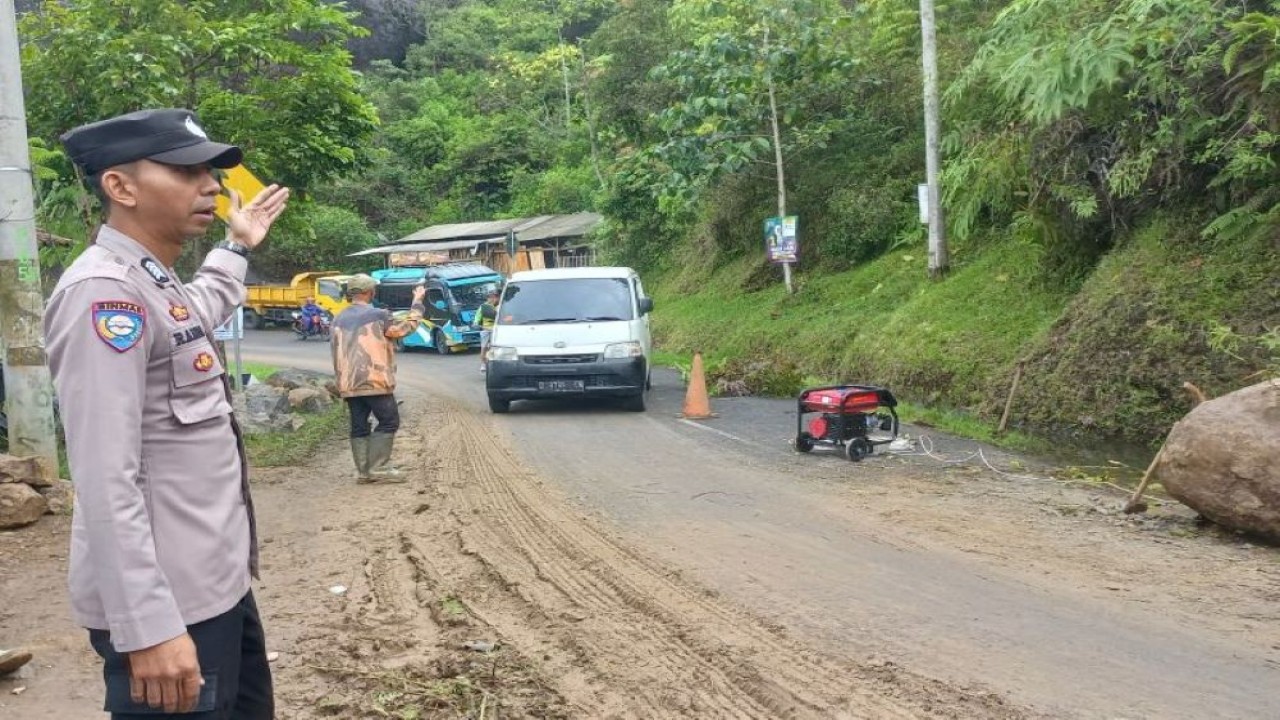 Petugas melakukan pengamanan di jalur yang terdampak bencana tanah longsor wilayah Batu Tumpang, Kecamatan Banjarwangi, Kabupaten Garut, Jawa Barat, Rabu (31/1/2024). (ANTARA/HO-Polsek Banjarwangi)